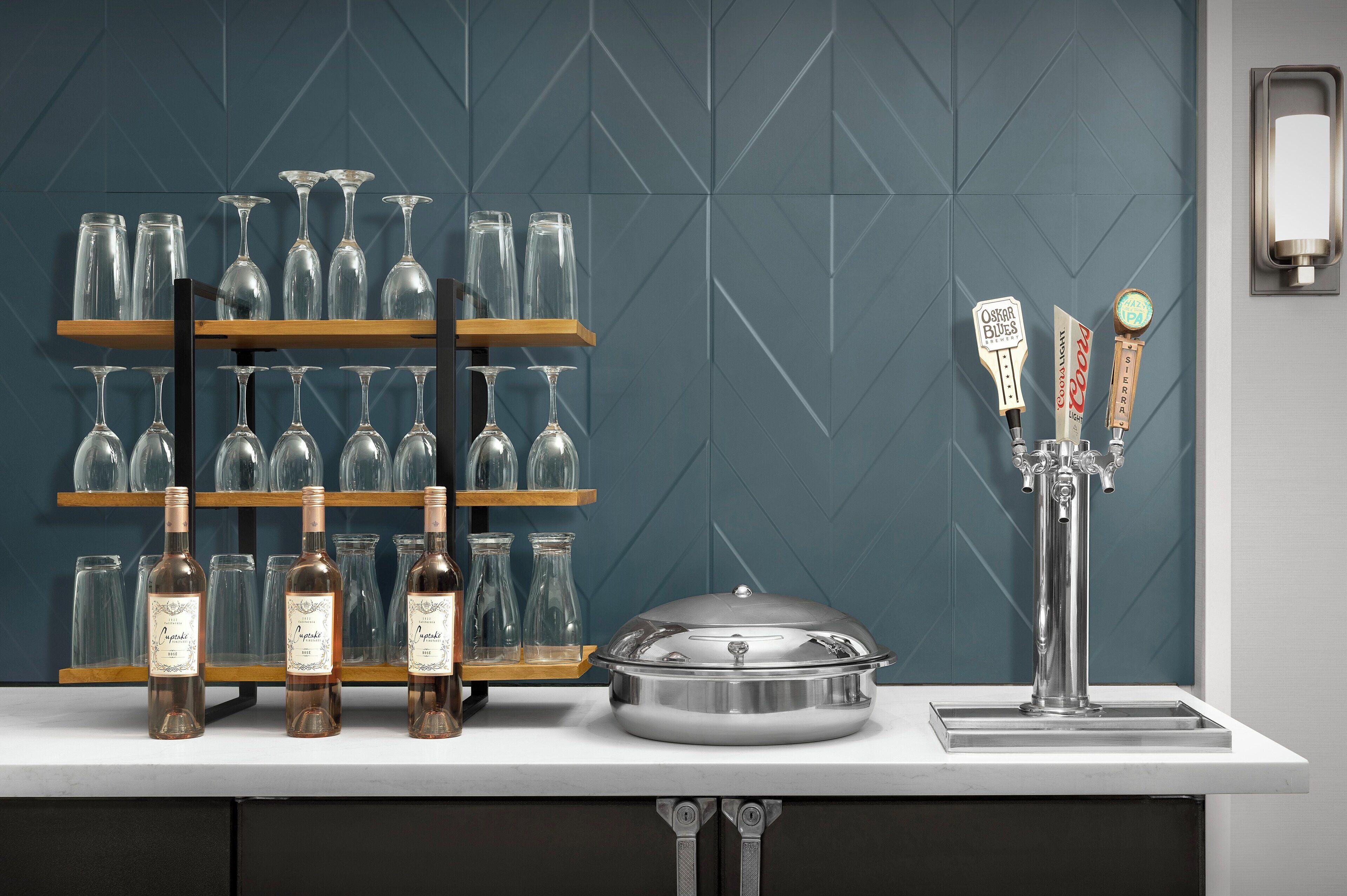 A bar area with wine bottles, glasses, and a tap labeled "Oscar's Bikes."