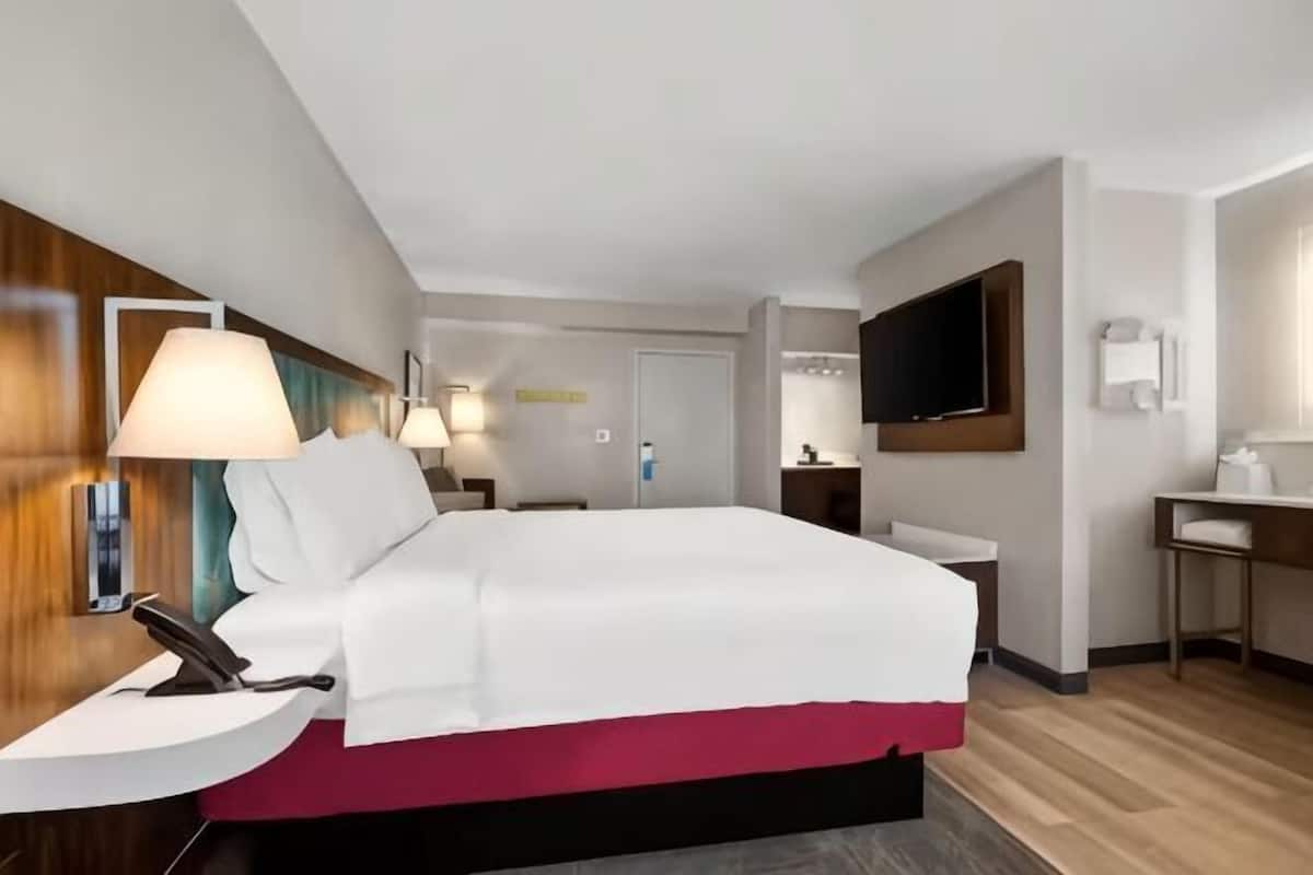Escritorio, cortinas opacas, tabla de planchar con plancha