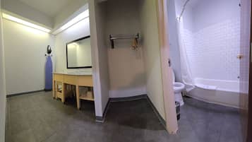 A bathroom with a toilet, a sink, a mirror, and a bathtub.