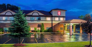 A hotel with a parking lot and a covered entrance.