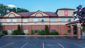 Un hôtel Red Roof Inn & Suites avec une façade en briques, de nombreuses fenêtres et un parking.