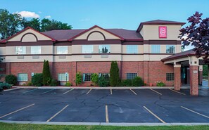 A Red Roof Inn & Suites with a brick facade, multiple windows, and a parking lot. - Red Roof Inn & Suites Lake Orion/ Auburn Hills (Lake Orion)