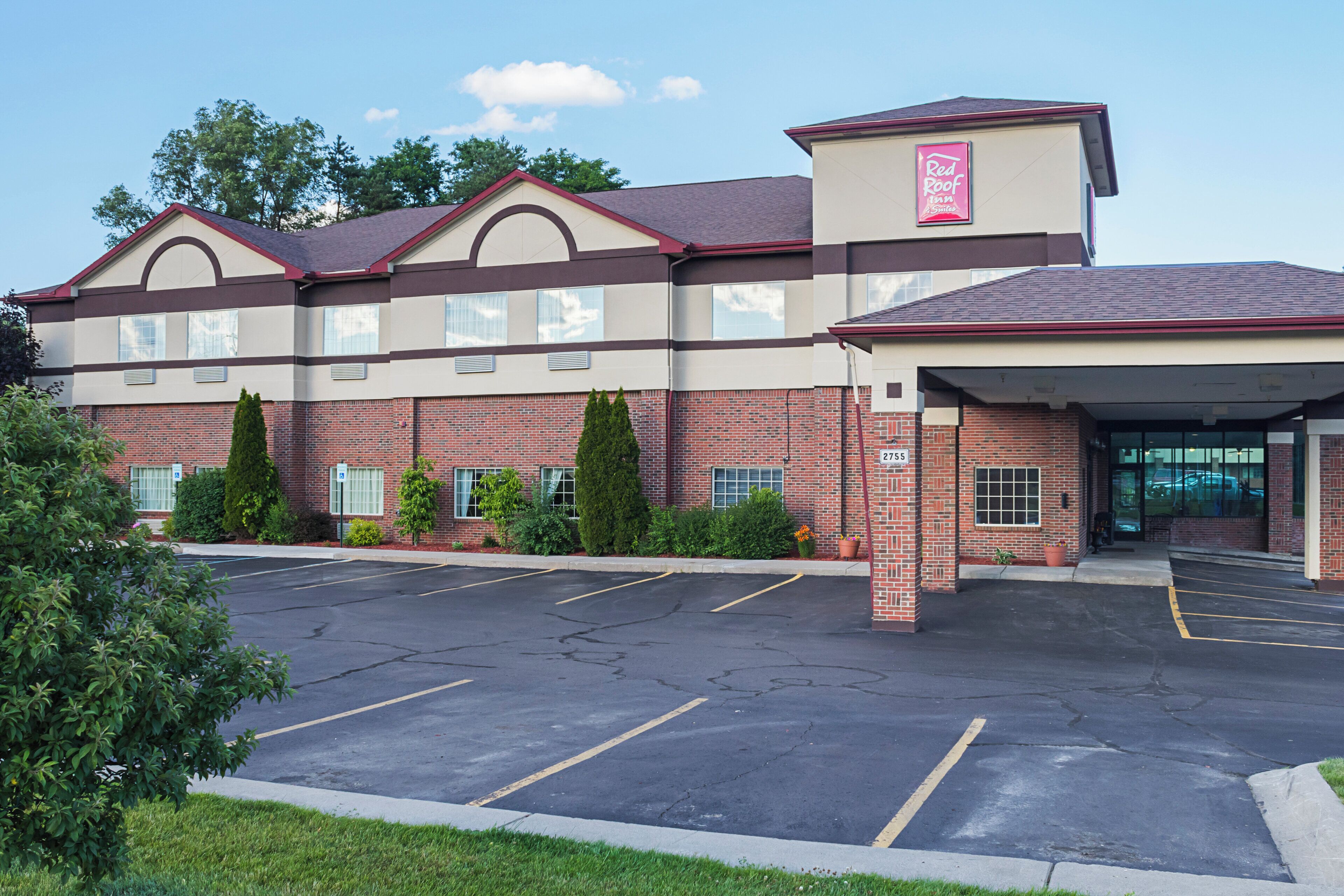 A Red Roof Inn with a parking lot and a brick facade.