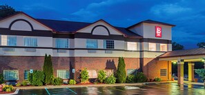 A Red Roof Inn with a brick facade, multiple windows, and a parking lot.