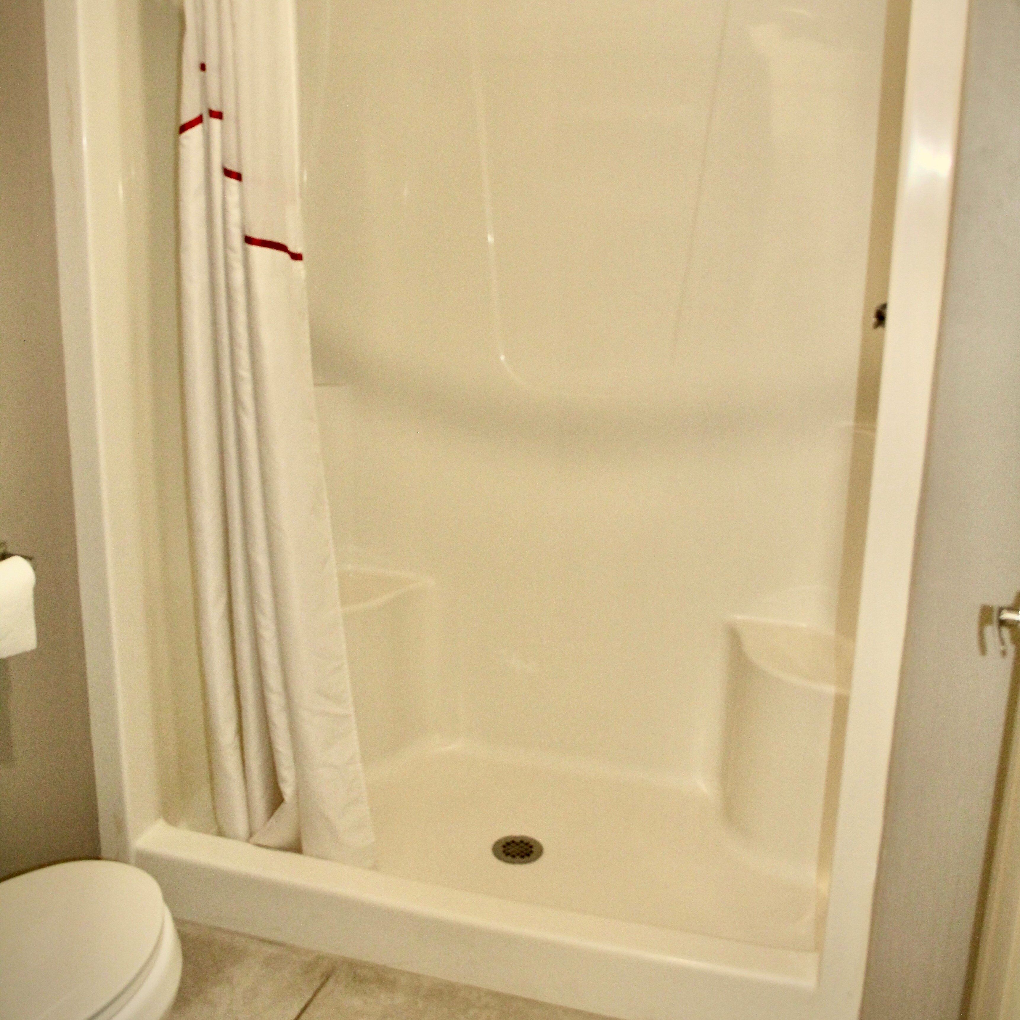 A bathroom with a bathtub, toilet, and a shower curtain.