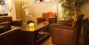 A reception area with leather chairs, a reception desk, a potted plant, and a clock on the wall.