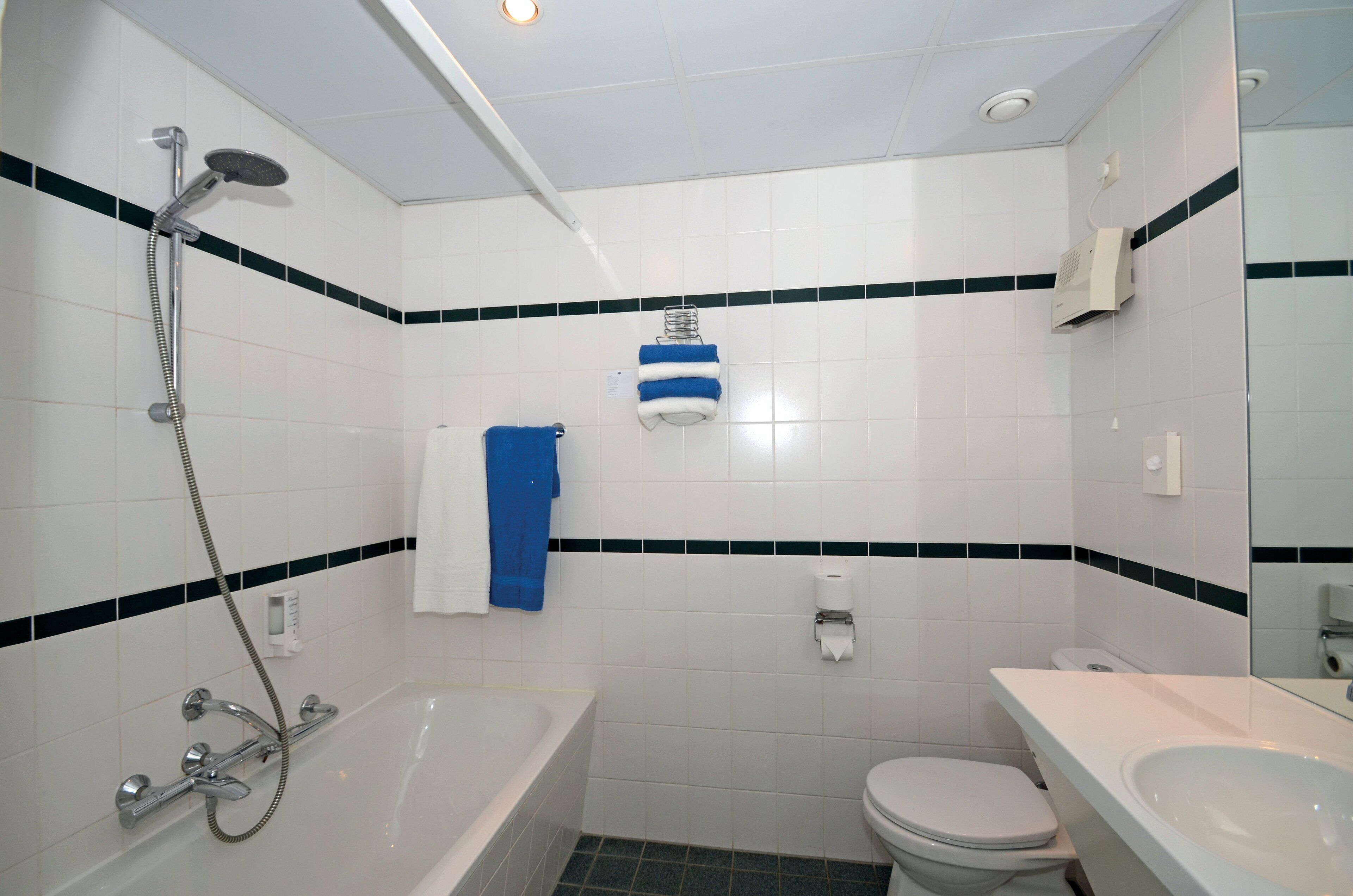 A bathroom with a bathtub, toilet, and sink.