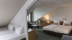 Una habitación de hotel moderna con cama tipo loft, un escritorio y una zona de estar.