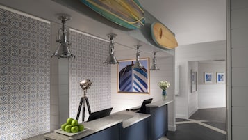 Reception area with a clean design, featuring a reception desk, geometric patterned wall, and unique surfboard art.