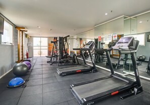 Une salle de sport équipée de tapis de course, de ballons d'exercice et d'appareils de musculation.
