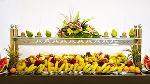 A buffet table with a variety of fruits and a floral centerpiece. - Gafy Resort Aqua Park (Sharm El Sheikh)