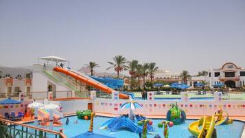 A water park with slides, a pool, and a covered area with umbrellas.