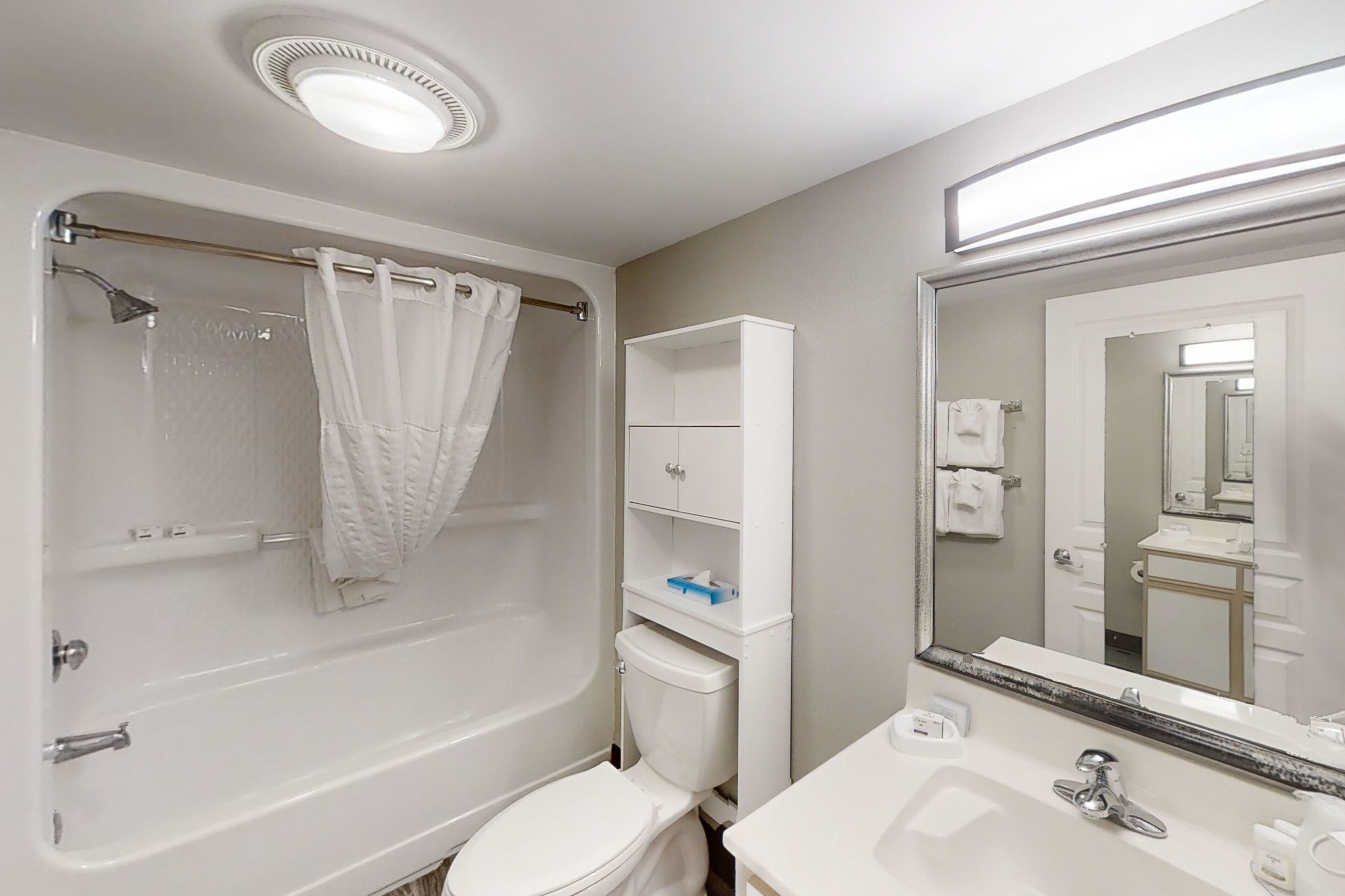 A bathroom with a bathtub, toilet, and sink.