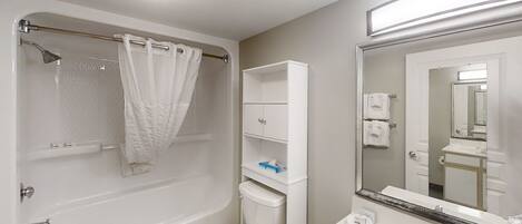 A bathroom with a bathtub, toilet, and sink.