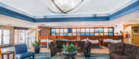 A lobby with a large chandelier, seating area, and a reception desk.