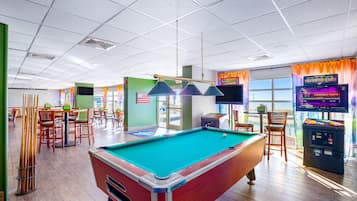 Enjoy a game of pool or challenge friends at the pool table in this social space with tables, chairs, and arcade games.