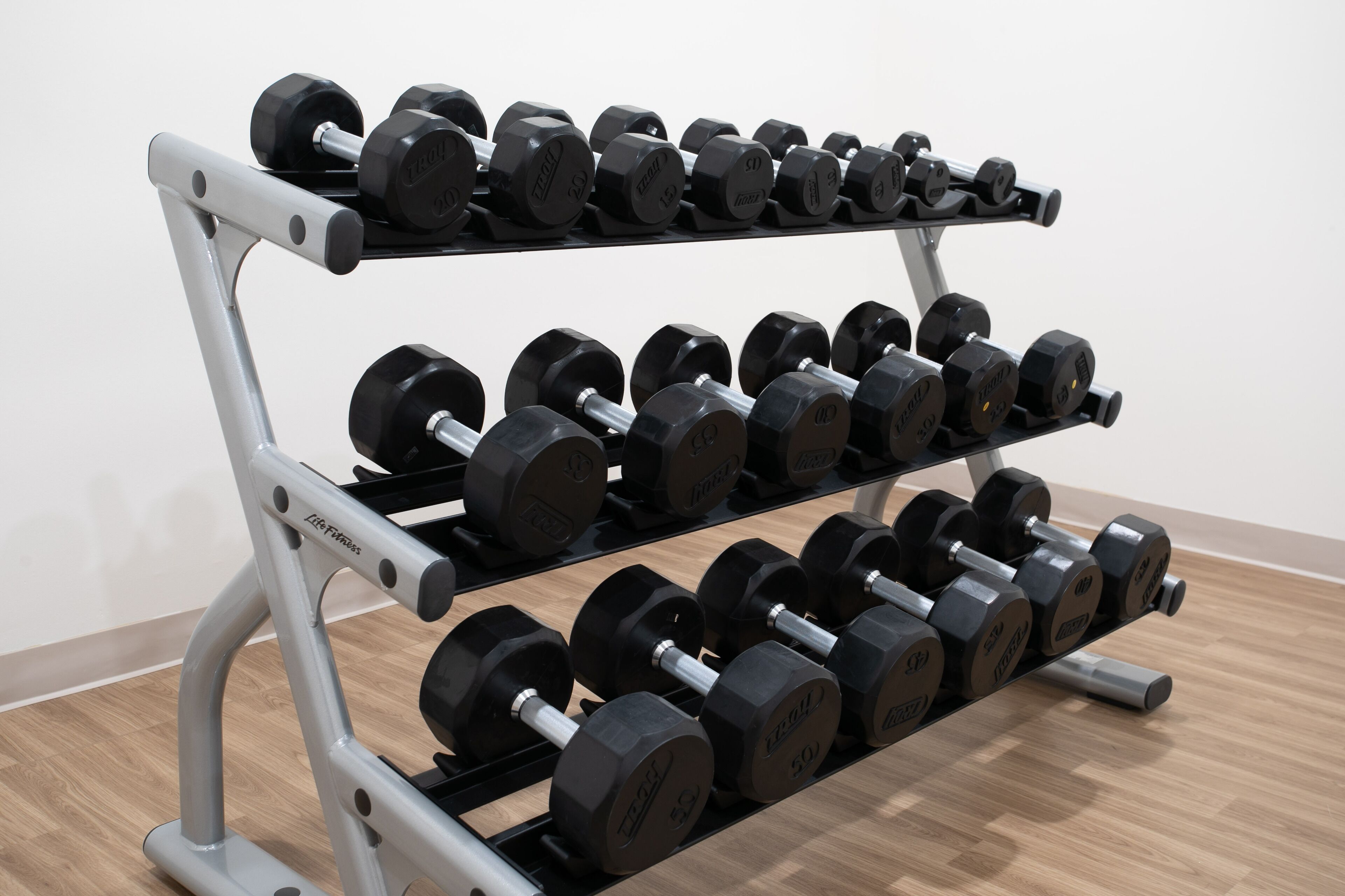 A weightlifting rack with multiple sets of dumbbells.