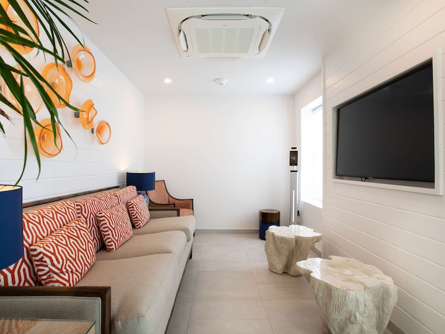 A modern living room with a sofa, a television, and decorative elements like a plant and wall art.