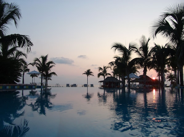 Una piscina al aire libre, sombrillas, tumbonas