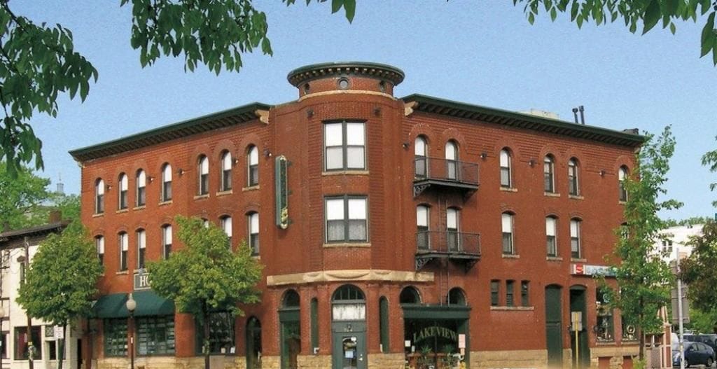 A historic hotel with a corner building, multiple windows, and a green awning.