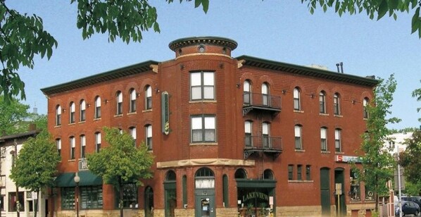 A historic hotel with a corner building, multiple windows, and a green awning. - Hotel Ruby Marie (Madison)