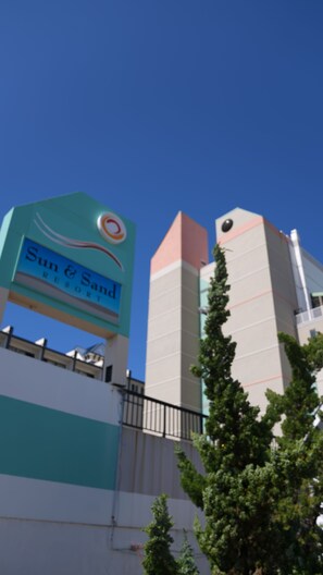 A sign for Sun & Sand Resort with a clear blue sky in the background. - Sun and Sand Resort Oceanfront Suites  (Virginia Beach)