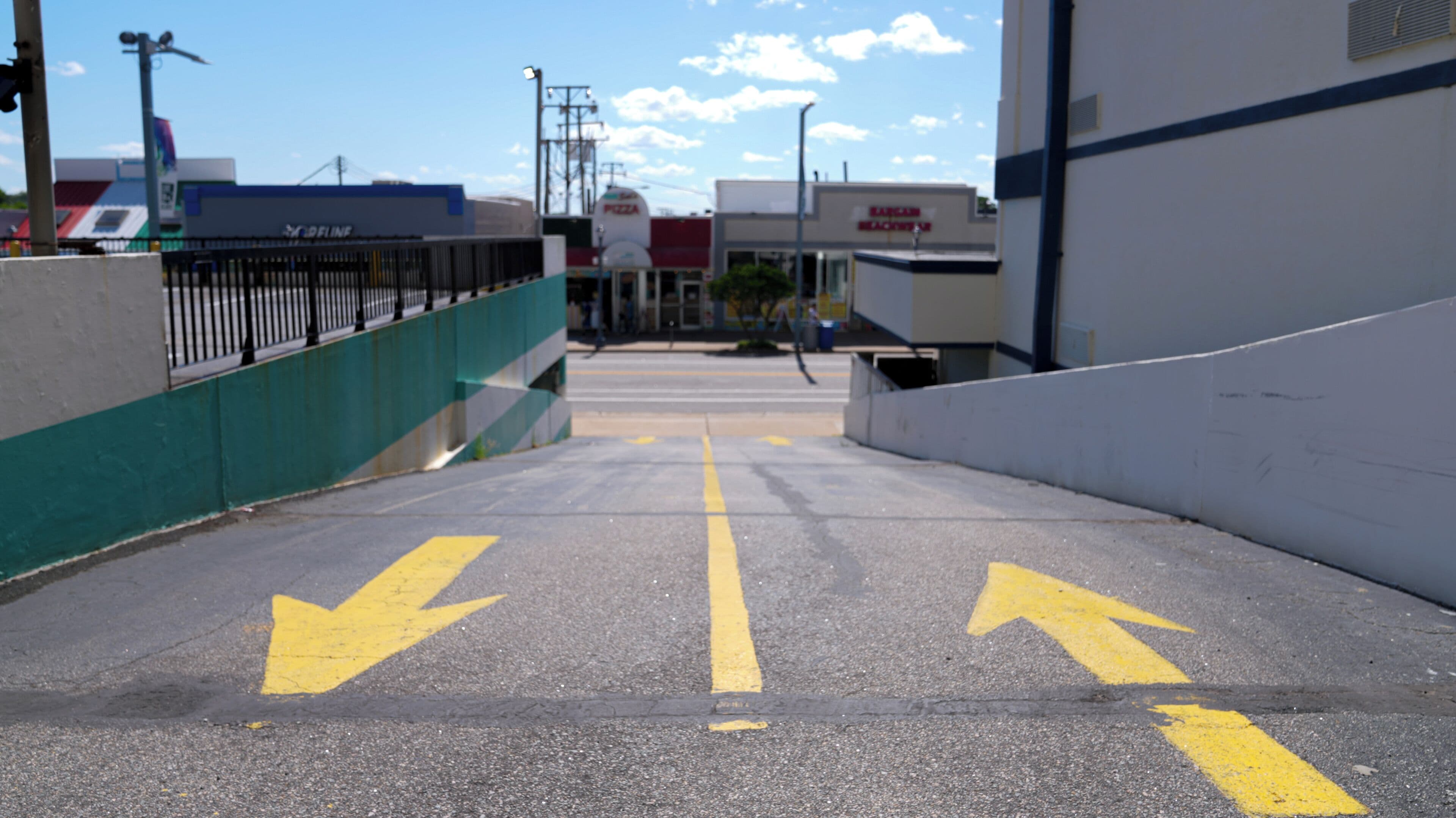 Un área de estacionamiento con flechas direccionales amarillas en el suelo.
