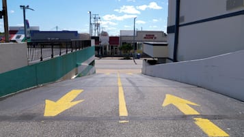 Un área de estacionamiento con flechas direccionales amarillas en el suelo.