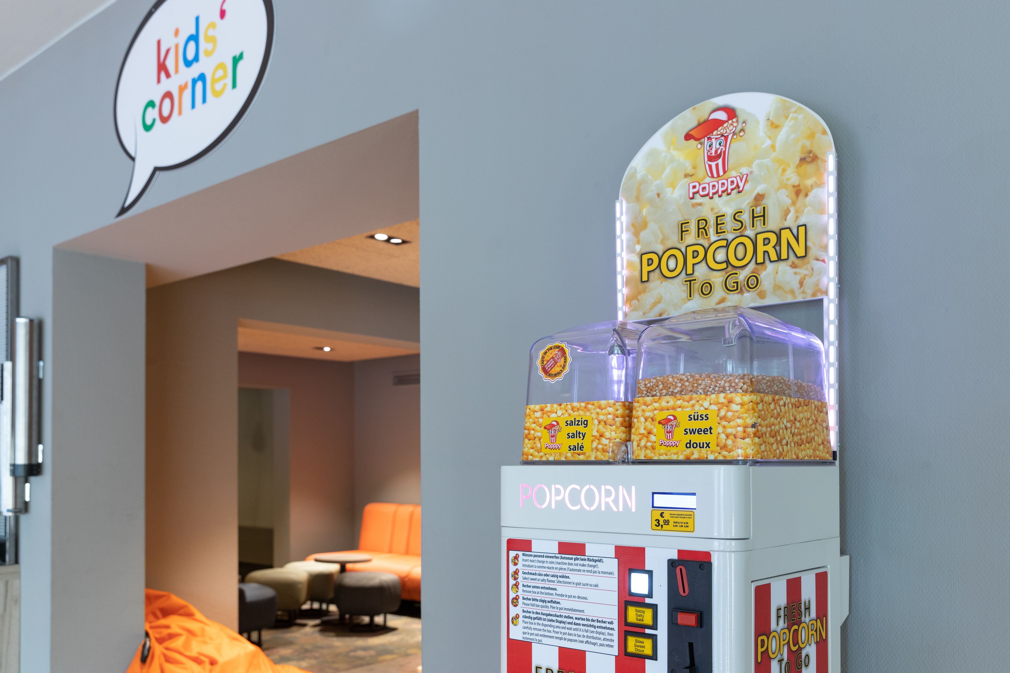 A popcorn vending machine labeled "Popsky Fresh Popcorn To Go" with options for "salzig" and "süß" flavors.