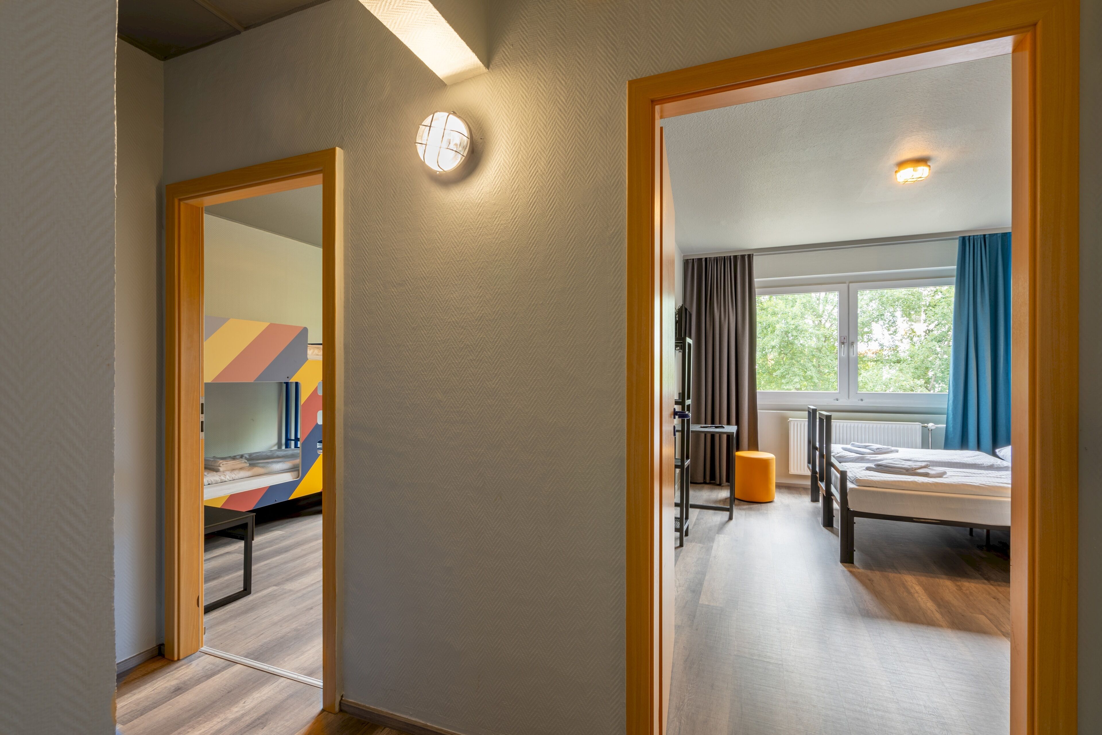 Ein modernes Hotelzimmer mit Bett, Schreibtisch und einem Fenster mit Vorhängen.