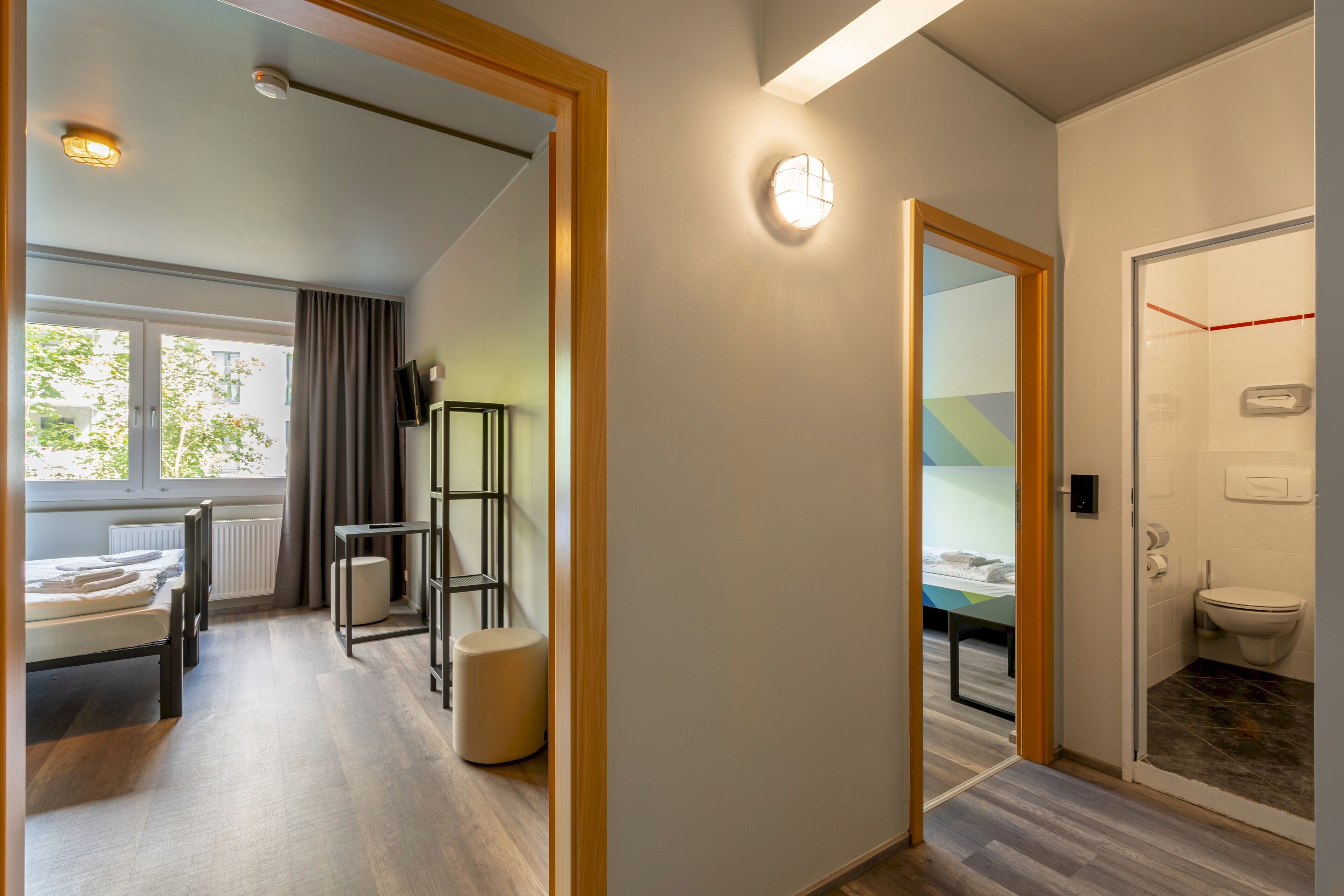 Ett modernt hotellrum med en säng, ett nattduksbord och utsikt över omgivningarna.