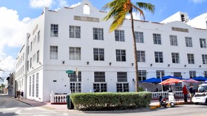 A white building with multiple windows and a palm tree in front. - Beach Park Hotel (Miami Beach)