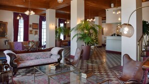 A lobby with a checkered floor, wooden ceiling, and a mix of seating including a sofa and chairs. - Beach Park Hotel (Miami Beach)
