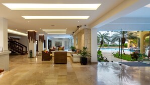 A spacious lobby with a marble floor, a staircase, and a view of a pool area. - Hotel Playa Azul Cozumel (Cozumel)