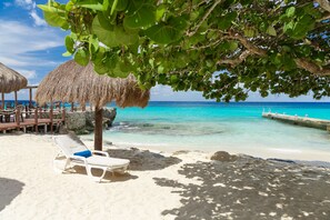 Playa privada, playa de arena blanca, camastros y sombrillas 