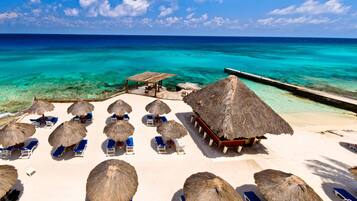 Pantai pribadi, pasir putih, kursi berjemur, dan payung pantai