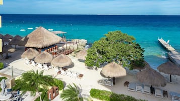 En privat strand, hvidt sand, liggestole, parasoller