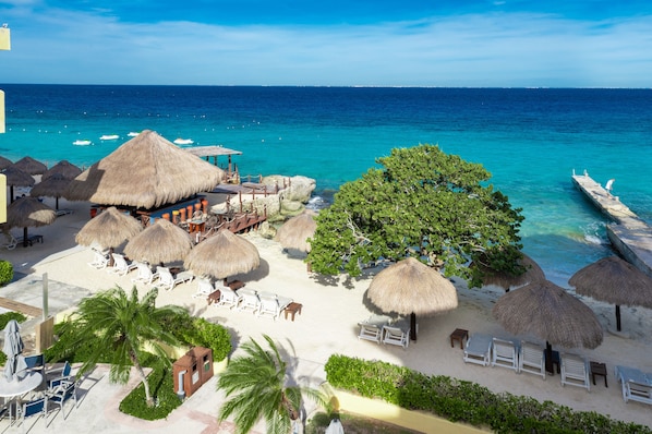 Plage privée, sable blanc, chaises longues, parasols