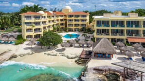 A resort with a pool, beach, and thatched-roof structures. - Hotel Playa Azul Cozumel (Cozumel)