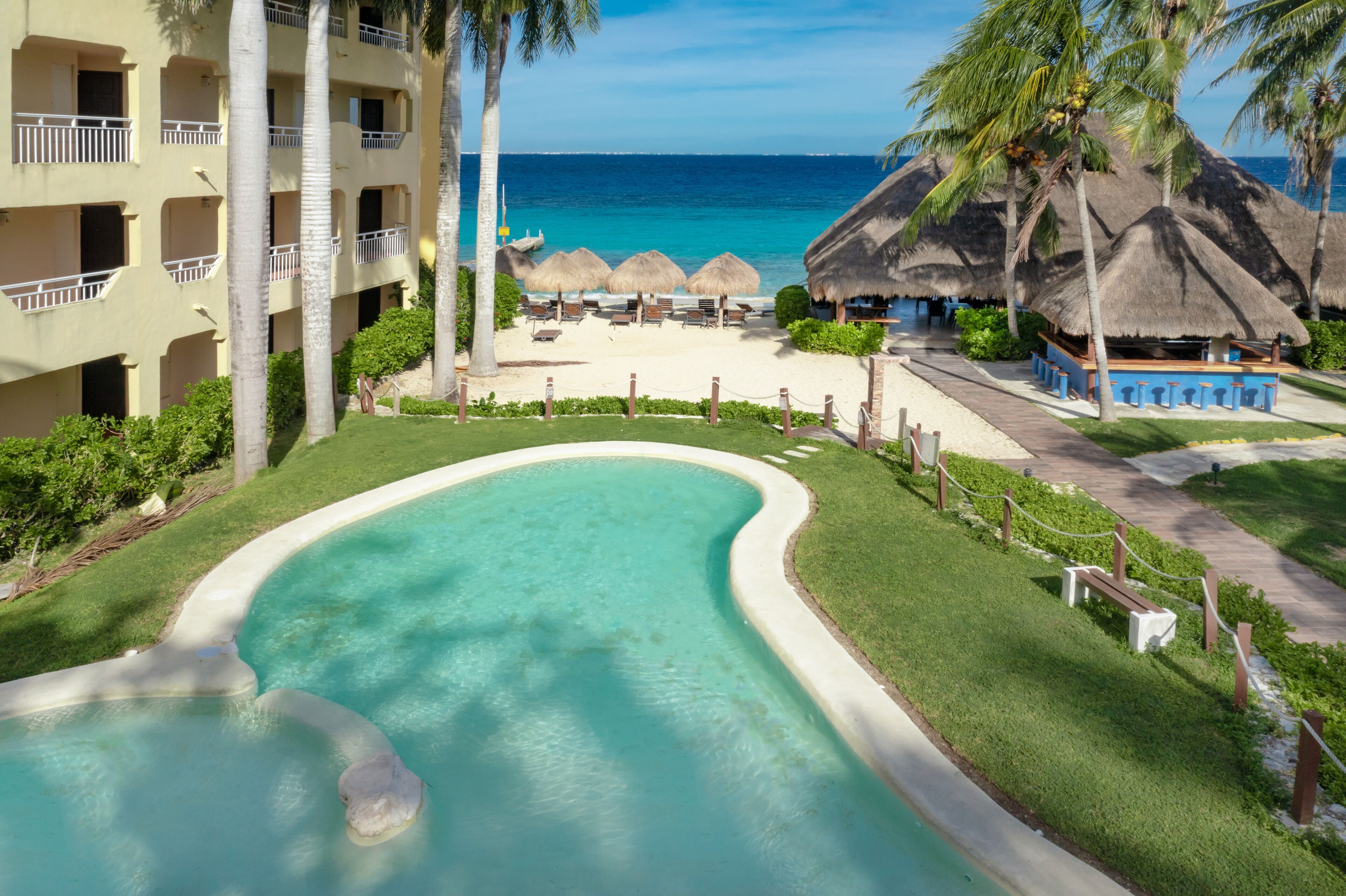 Una piscina al aire libre, sombrillas, sillones reclinables de piscina