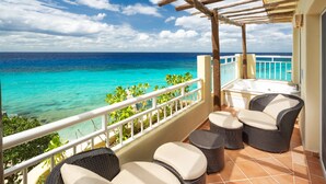 A balcony with wicker furniture, a view of the ocean, and a white railing. - Hotel Playa Azul Cozumel (Cozumel)