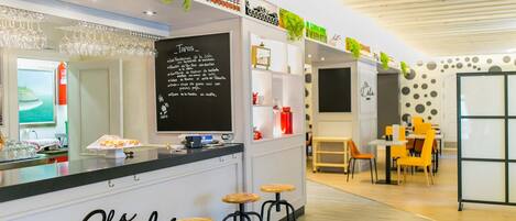 A modern gastropub with a blackboard menu, wooden stools, and a clean, well-lit interior.
