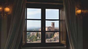 A window with four panes, curtains, and wall sconces.
