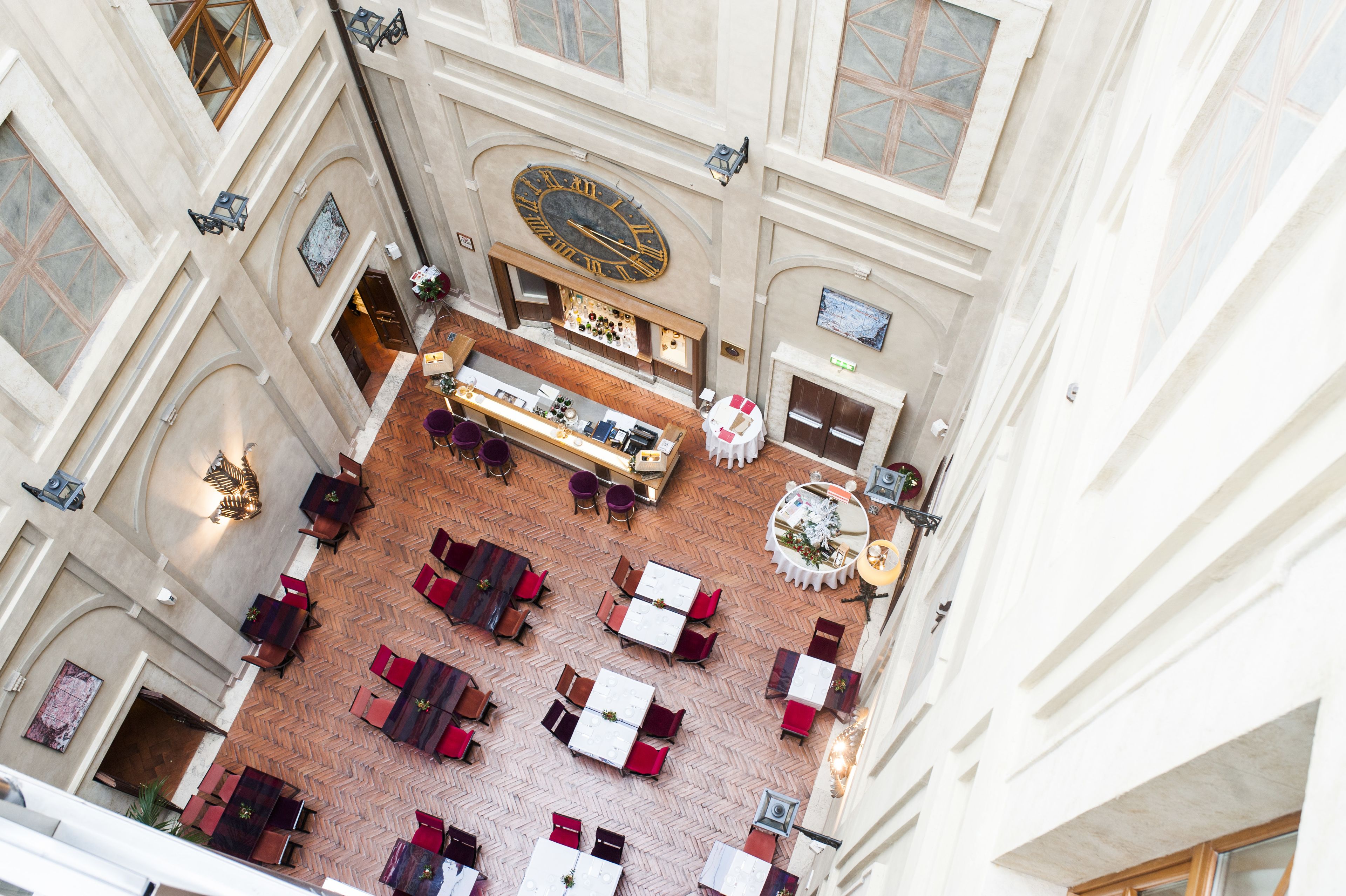 A spacious atrium with a central clock, multiple seating areas, and a reception desk.
