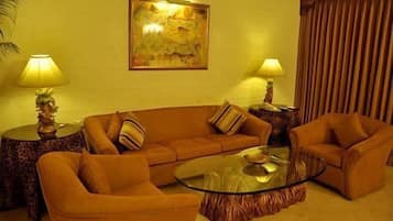 Deluxe Suite | Living room | 40-inch flat-screen TV with cable channels, TV
