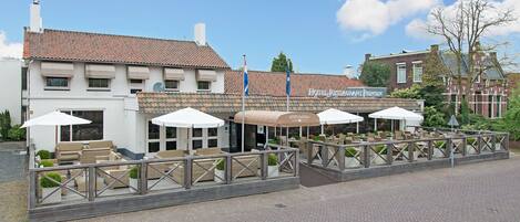 Un hotel con asientos al aire libre y un letrero que dice "HOTEL RESTAURANT PRINSEN".