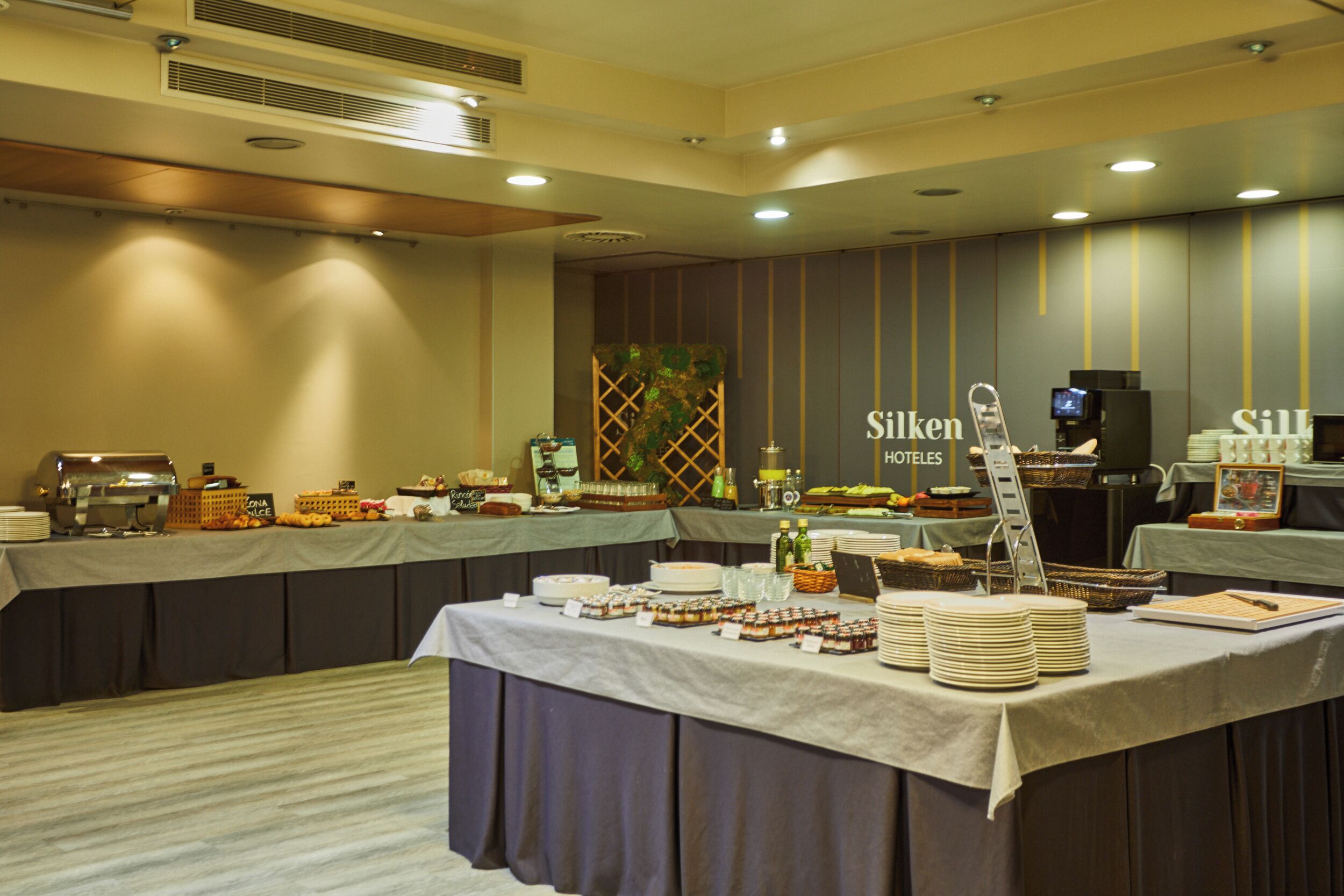 A buffet setup with various food items and a coffee station in a hotel room.