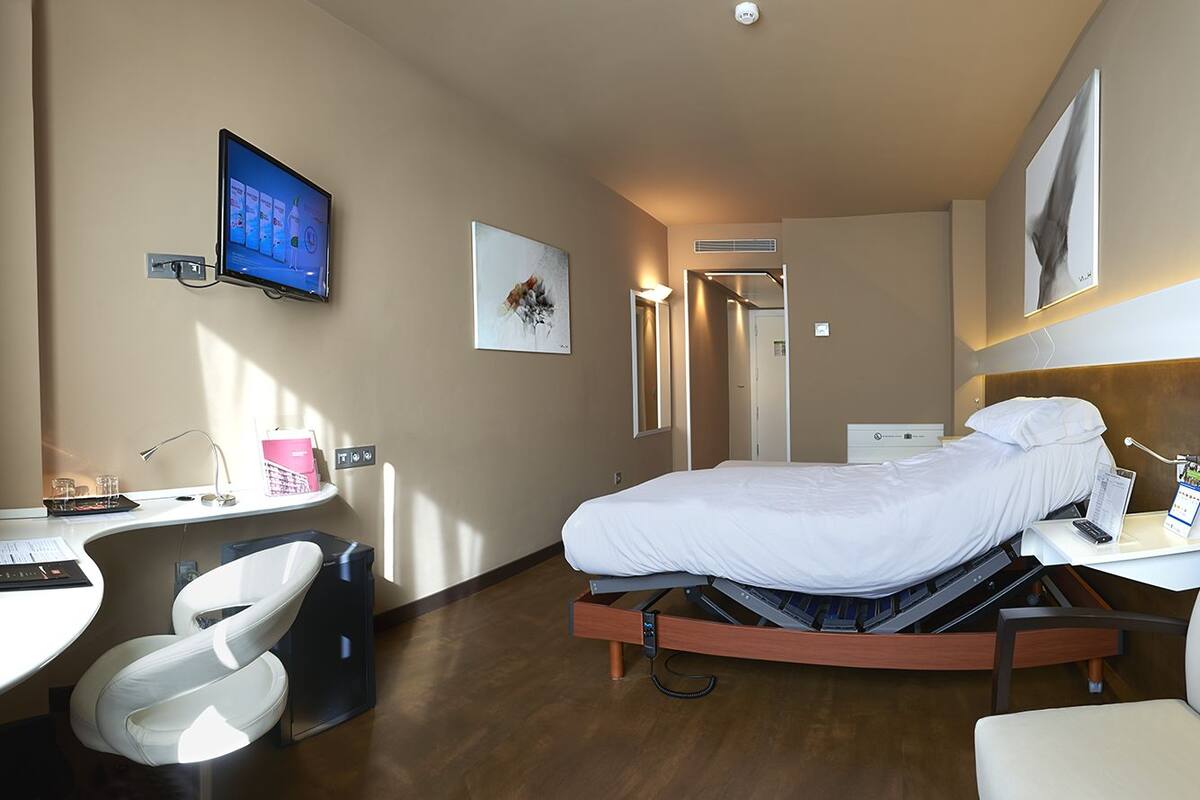 Une chambre d’hôtel équipée d’un lit, d’un bureau, d’une chaise et d’un téléviseur.