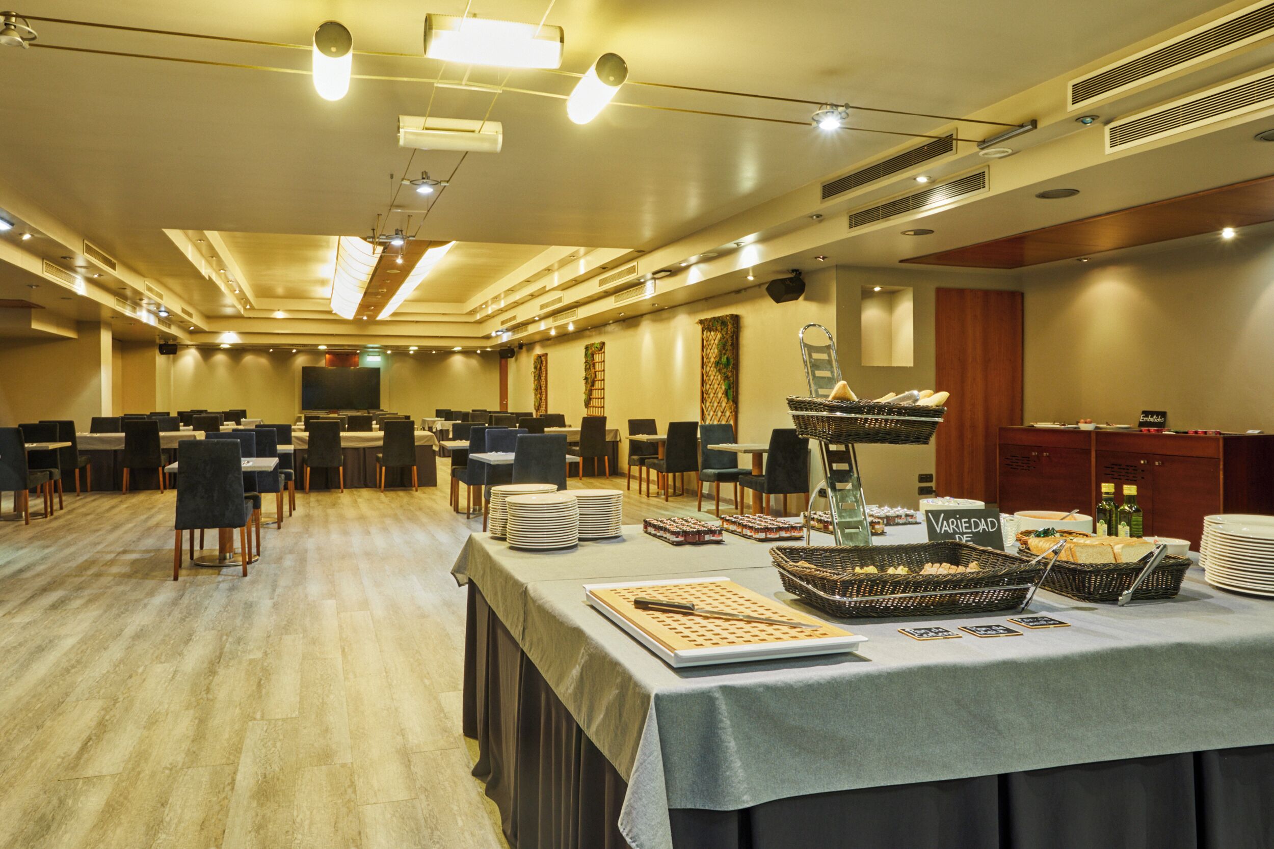 A conference room with tables, chairs, and buffet-style food service.