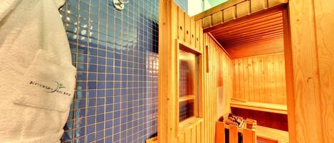 Una sala de sauna con una puerta de madera, una toalla colgada en la pared y una ventana.
